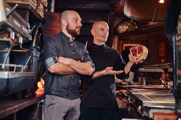 Chef and his assistant presenting a fresh steak before cooking