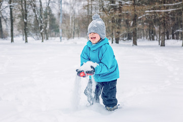 Fototapeta na wymiar Boy playing in the snow outside in winter