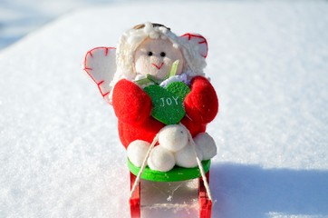 Christmas toys angel in a sleigh, in a snowy forest, outdoors.
