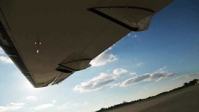 Close-up wing of the plane shines the sun on the airfield arrival aviation flight aerial clouds travel air airplane fly blue sky transportation transport wing trip airport airliner