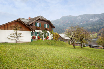 Town of Grundlsee on the shore of lake Grundlsee on a foggy autumn day. View of the Alps. Region of Salzkammergut, federal state of Styria, Austria, Europe.