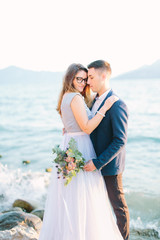 Obraz premium young beautiful wedding couple in blue clothes posing near the Garda lake in Sirmione