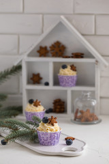 Tasty blueberry muffins with cream on white wooden table, Christmas dessert