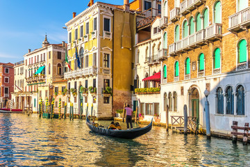 A gondolier in his gondola in the Grand Canal of Venice in front - obrazy, fototapety, plakaty