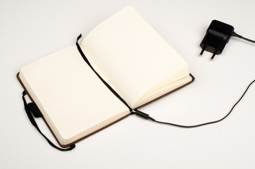 Small paper notebook and battery charger