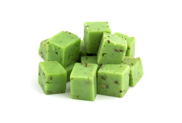 Cheese cubes of green color on a white background. Cheese pesto closeup on a white background..