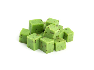 Cheese cubes of green color on a white background. Cheese pesto closeup on a white background..