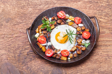 Tiroler Gröstl in einer Pfanne auf Holz