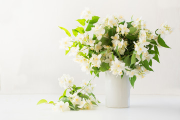 Beautiful bouquet of jasmine flowers in vase. Copy space.