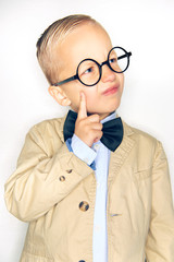 Little boy wearing a bowtie and glasses deep in thought