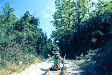 One woman sitting on the rail tracks and turned against camera