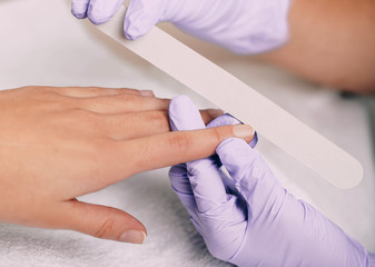Fototapeta na wymiar woman getting a hygienic manicure with nail file at nail salon