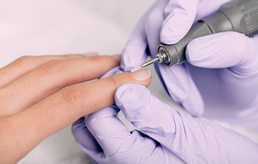 woman having hardware manicure at nail salon
