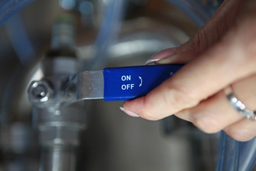 Female hand turning the switch or handle in the workplace. The concept of production or industry.Macro photo. Hand out.