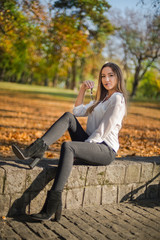 Naklejka na ściany i meble Photographing a girl during autumn with a blurred background