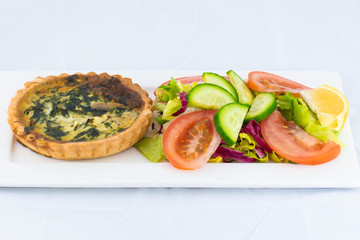 Spinach pie served with fresh salad with isolated white background