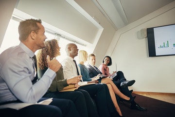 Smiling businesspeople watching a presentation in an office
