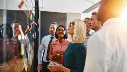 Diverse businesspeople standing in an office brainstorming with
