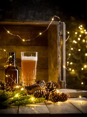 Foto auf Leinwand Beer in glass on wooden background with Christmas lights and pine cones © Eduard Zhukov