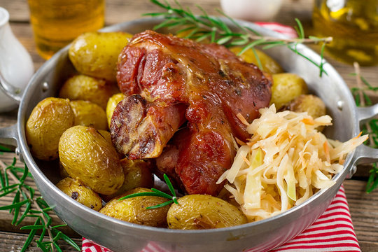 Pickled ham hock eisbein baked in oven with potatoes