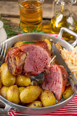 Pickled ham hock eisbein baked in oven with potatoes