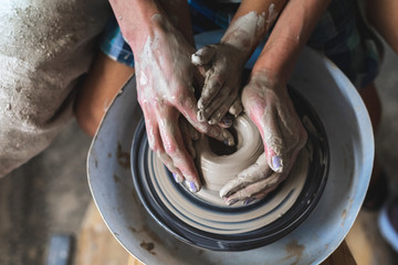 High angle above top flat lay view artist lady sit inside workspace studio teaching small boy work together create craft culture bowl dishes or tableware turn circular spin spend free time on class © brizmaker