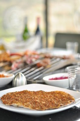 Traditional Cypriot meze and mix meat and chicken kebab table with charcoal barbecue on the table for self cooking during the eating time