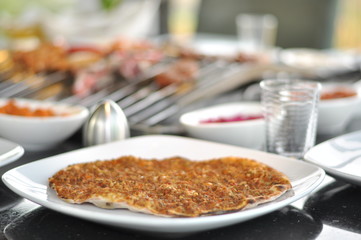 Traditional Cypriot meze and mix meat and chicken kebab table with charcoal barbecue on the table for self cooking during the eating time