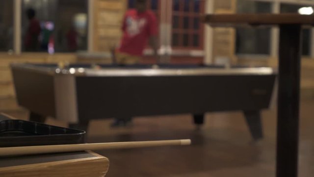 Slider shot of teens playing pool at retreat center pool hall 1