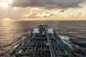 Oil product tanker is underway at sea at sunset. © momentscatcher