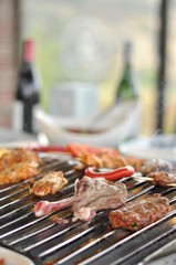 Traditional Cypriot meze and mix meat and chicken kebab table with charcoal barbecue on the table for self cooking during the eating time