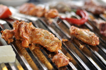 Traditional Cypriot meze and mix meat and chicken kebab table with charcoal barbecue on the table for self cooking during the eating time