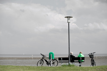 two people sitting on a bench with lamp