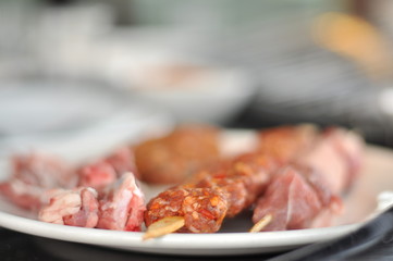 Traditional Cypriot meze and mix meat and chicken kebab table with charcoal barbecue on the table for self cooking during the eating time