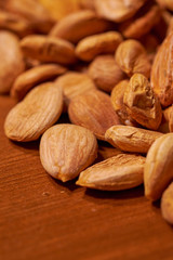 Scattered almond nuts on a brown background. Selective focus