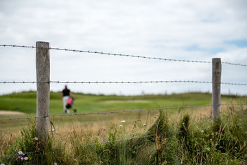 blurred golfer with barbed wire 