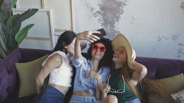 three female friends making selfies indoor