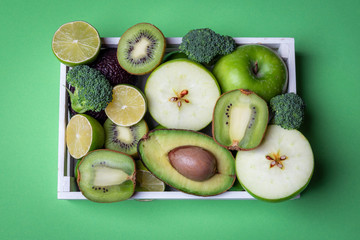 Healthy fruits and vegetables on a green table. Above view