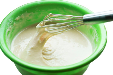 Products for the dough. Eggs and a bowl of dough on the table. Cooking the pancakes.