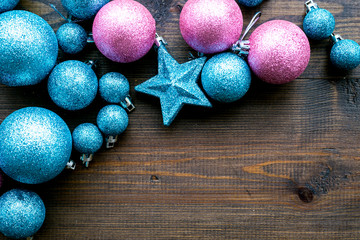 Toys for New Year tree 2019 background. Blue and pink balls and stars on dark wooden background top view copy space border