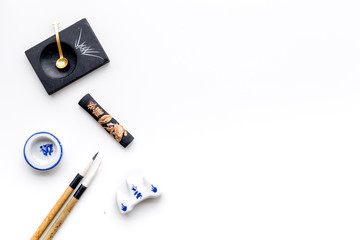 Accessories for chinese or japanese calligraphy. Special writting pen, ink on white background top view copy space