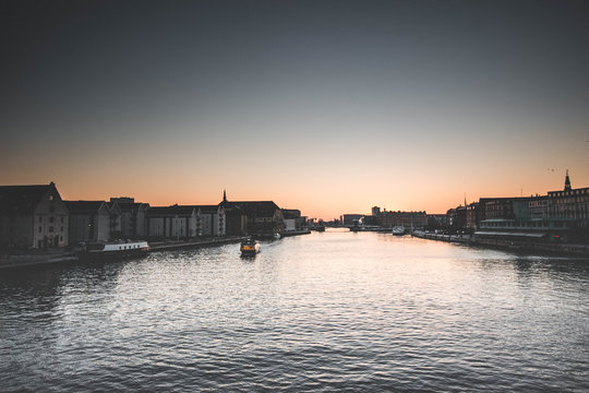 Yellow boat approaching in the port of Copenhagen at sunset