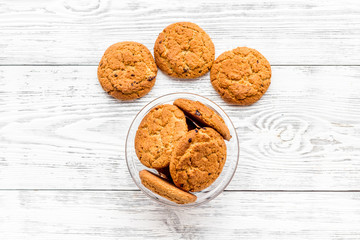 Homemade oatmeal cookies in glass bowl on white woden background top view copy space