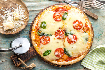 pizza margarita top view on a rustic wooden table, Margherita  cooked according to the traditional recipe of Italian cuisine