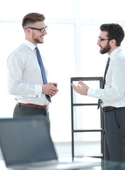 two businessmen talking standing in the office