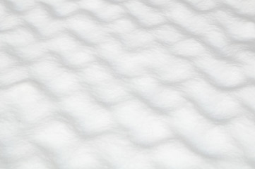 Fototapeta premium Repetitive pattern of hills and valleys in the snow. Snow texture detail with cells. Rare occurrence in nature.