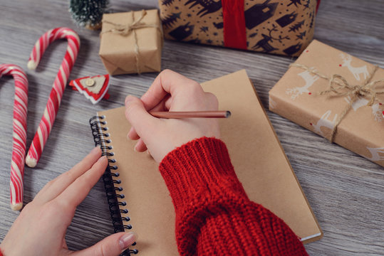 Woman girl female young concept. Pov first person point of view high angle top above close up photo of writer lady's hands hold pen make notes in red sweater jumper pullover