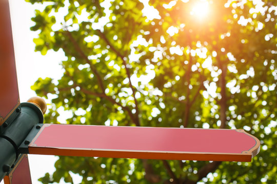 Red pointer mockup with free place shows the direction in summer forest with lights of sun. bottom view.