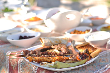 Traditional Cypriot meze and kebap barbecue party in the garden with delicious mix meat and chicken kebaps