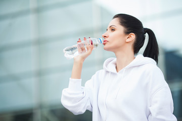 Fitness outdoor. Woman drinking bottle of water